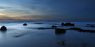Atheism: The basics Dark body of water with rocks, photo by Israel Gutiérrez