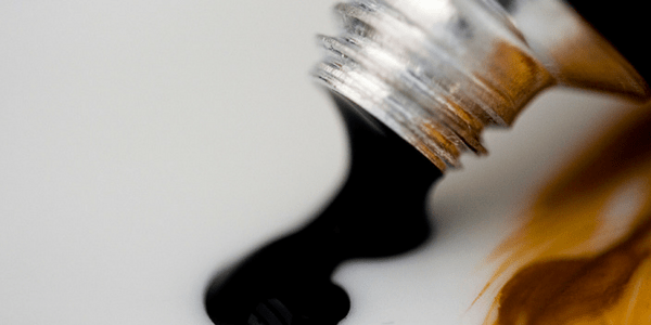 Tube of black paint on a surface, photo by Tom